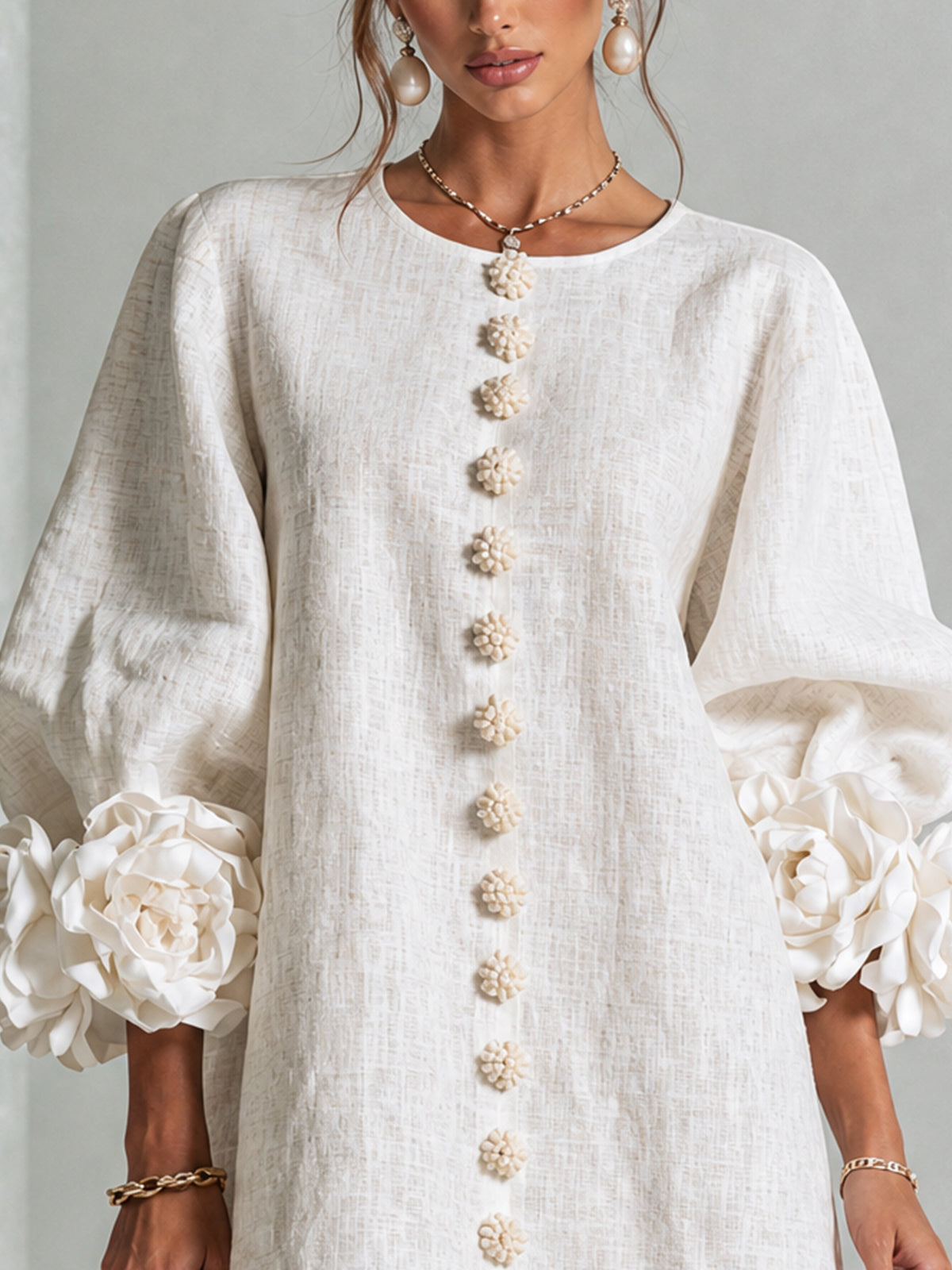 Mini-robe blanche à boutons en forme de fleurs et manches florales extravagantes